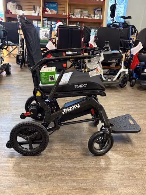 Interior facility with multiple mobility aids and wheelchairs on a wooden floor.