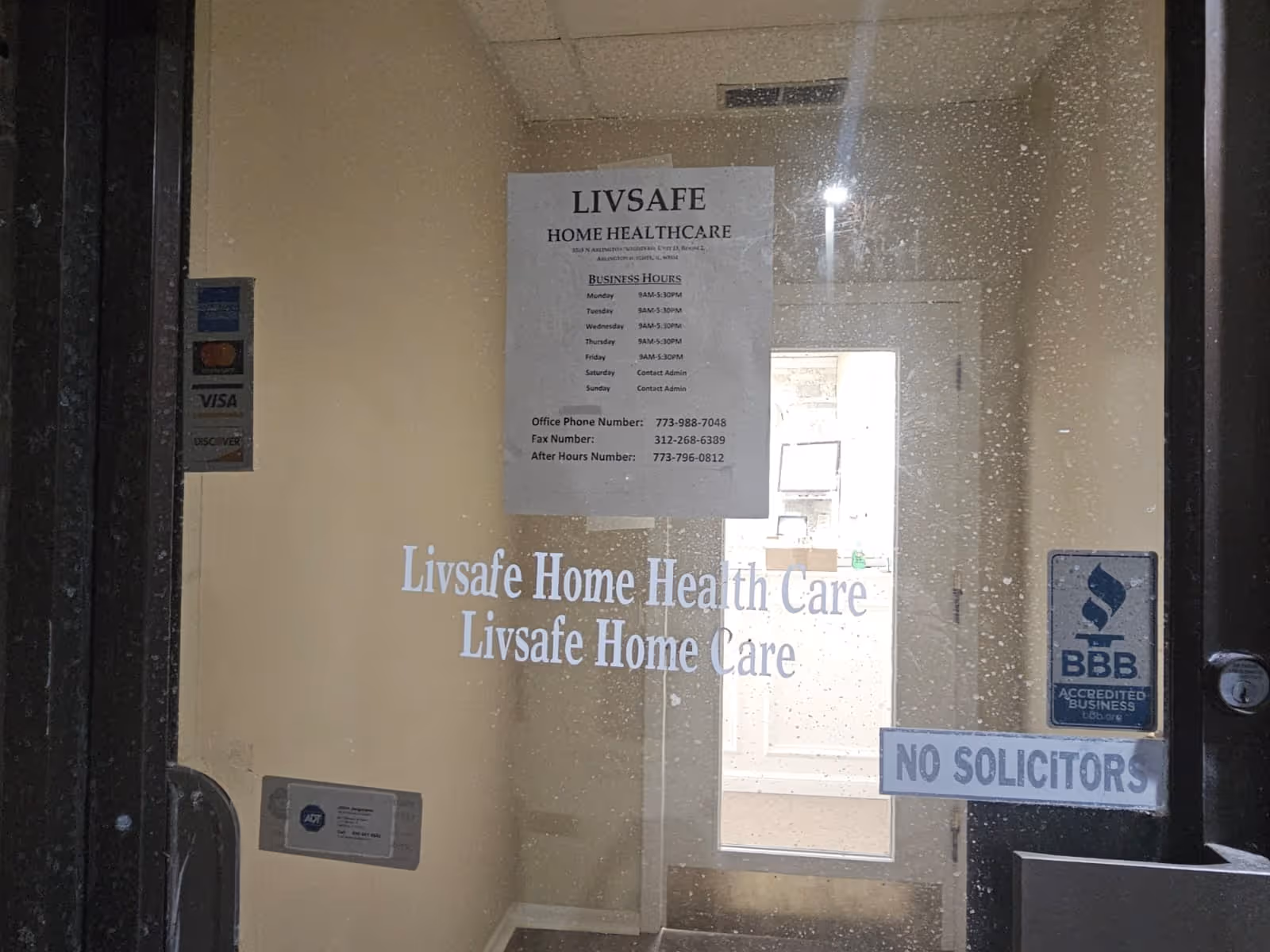 Glass entry door with LivSafe Home Health Care signage and no solicitors notice.