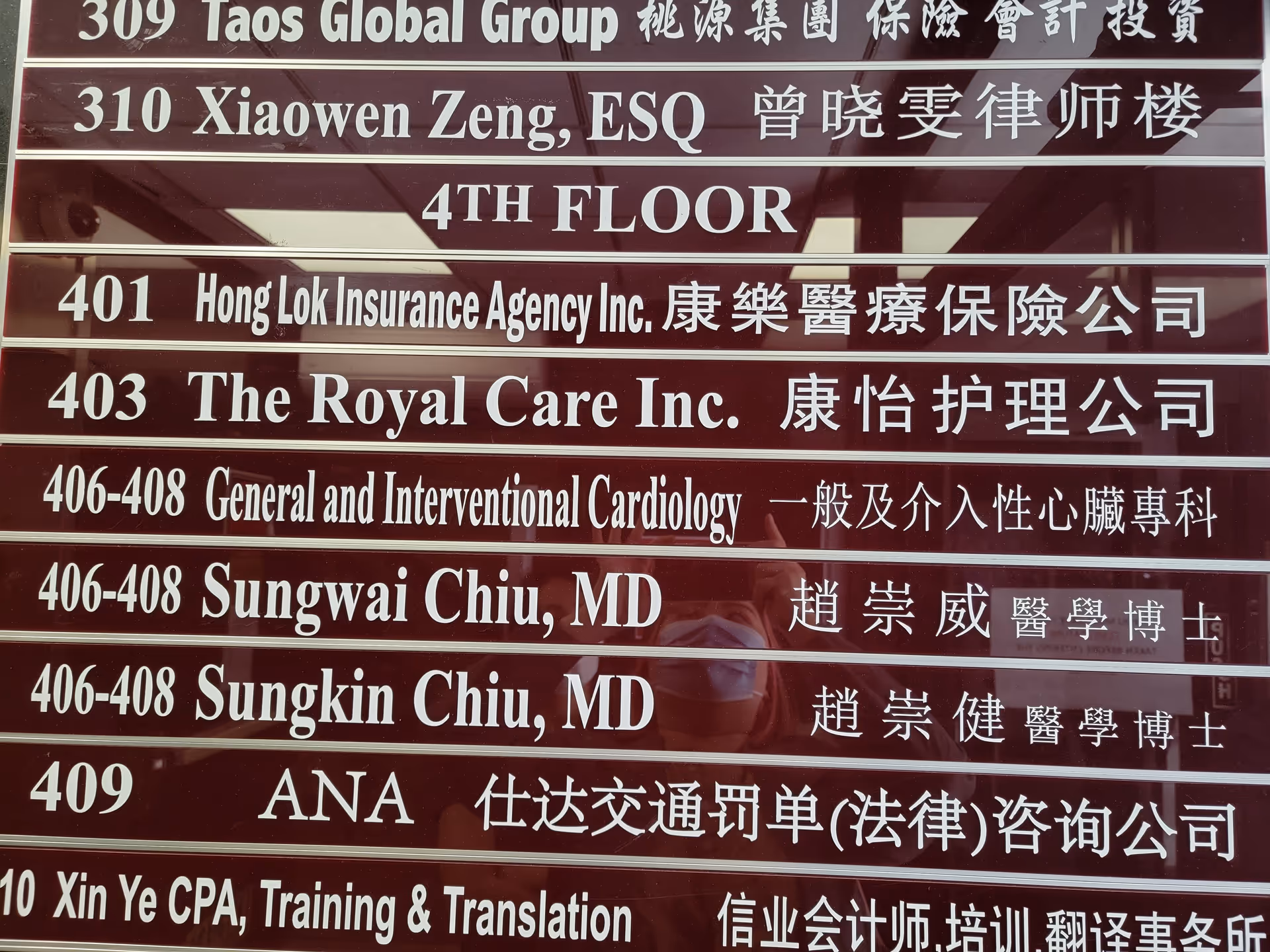 A maroon directory sign listing several company names and suite numbers.
