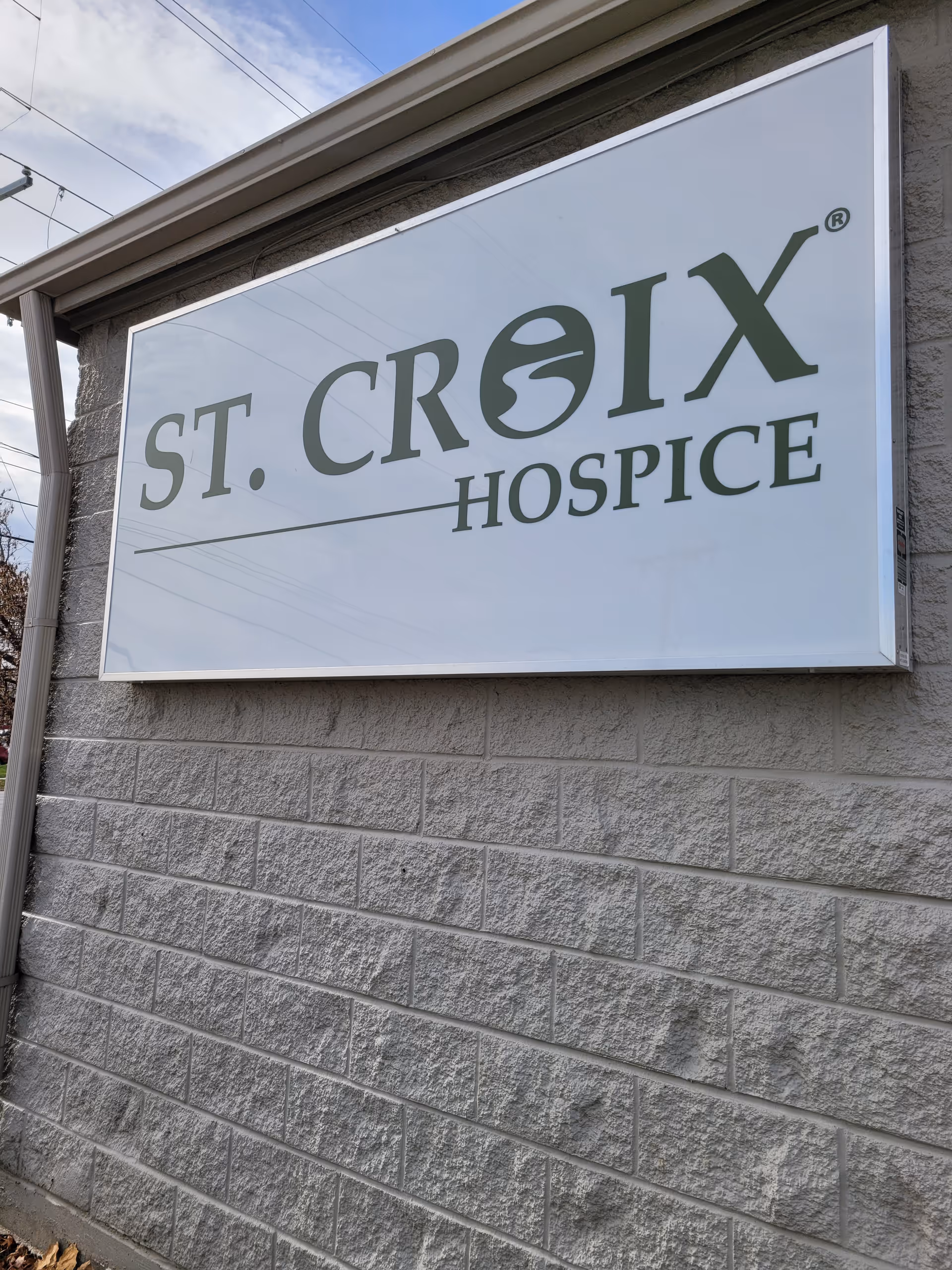 A large ST. CROIX HOSPICE sign mounted on a textured exterior wall.