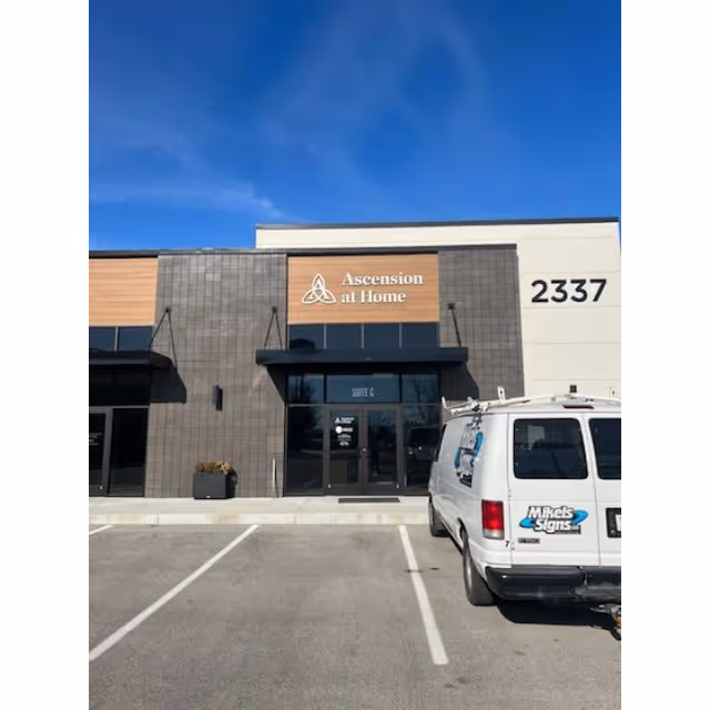 Exterior view of Ascension at Home facility entrance with a van in parking lot