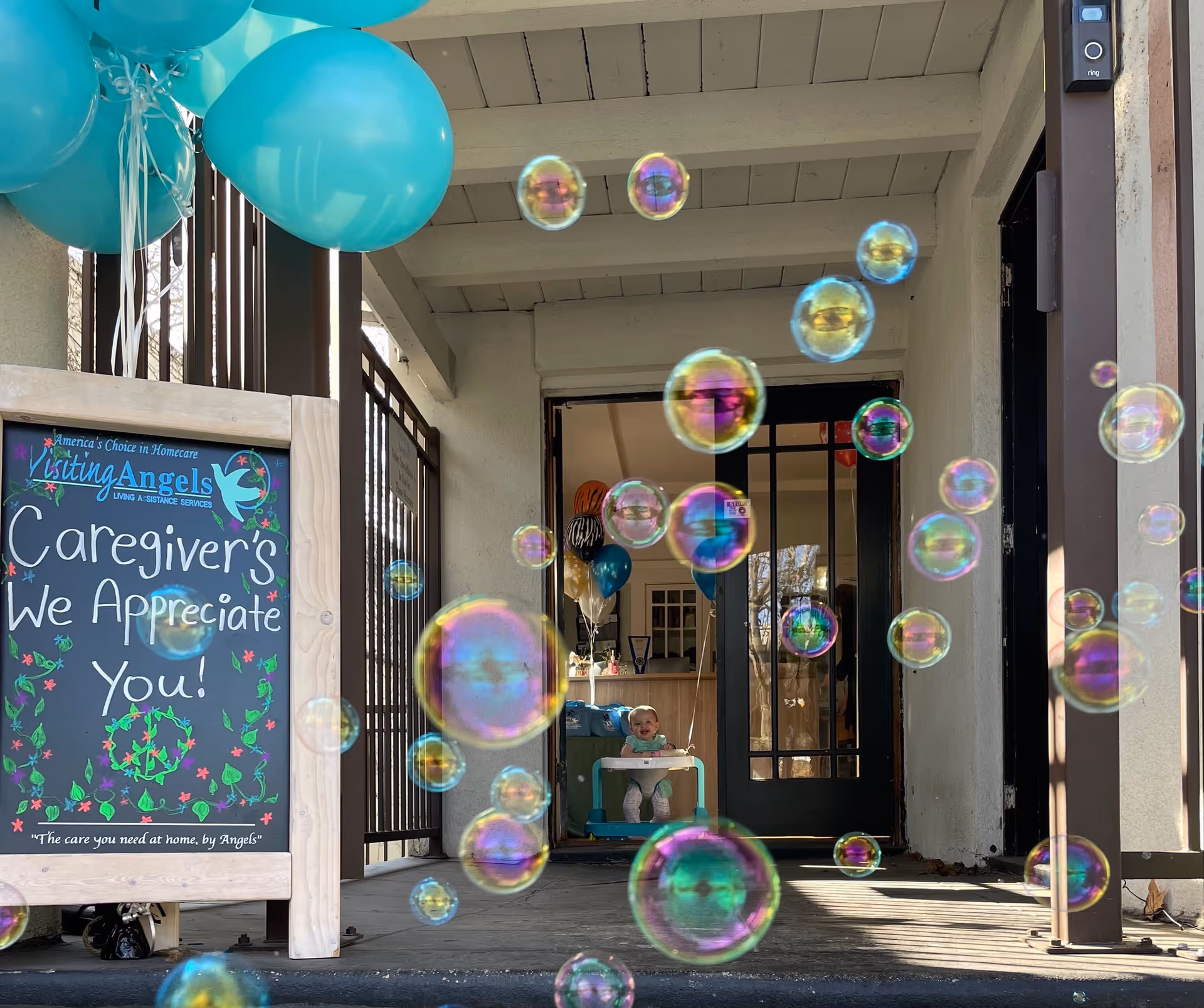 Front entrance of Visiting Angels Senior Home Care with balloons and a sign reading 'Caregiver's We Appreciate You'.