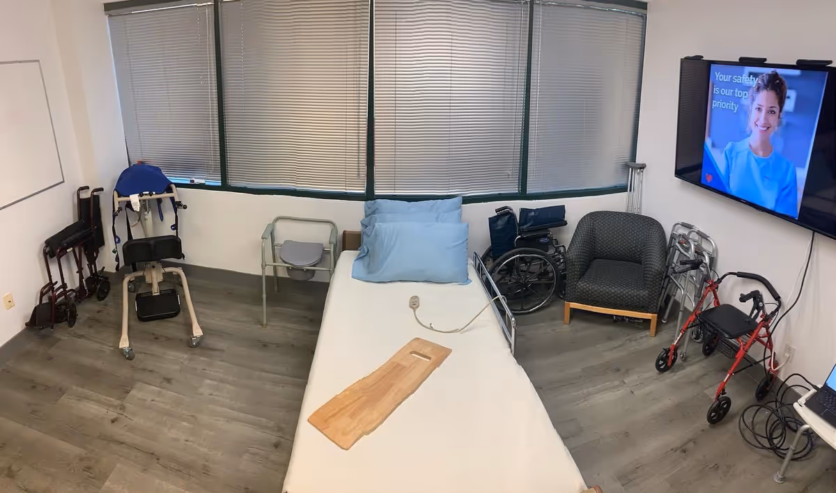 Interior patient room in a senior living facility with bed, chair, wheelchair, and TV.