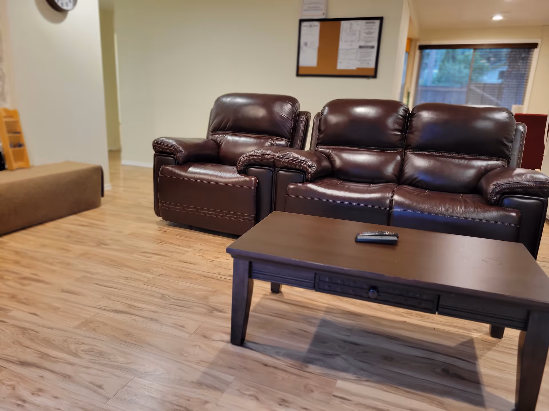 Lobby seating area with leather couches, coffee table, and bulletin board.