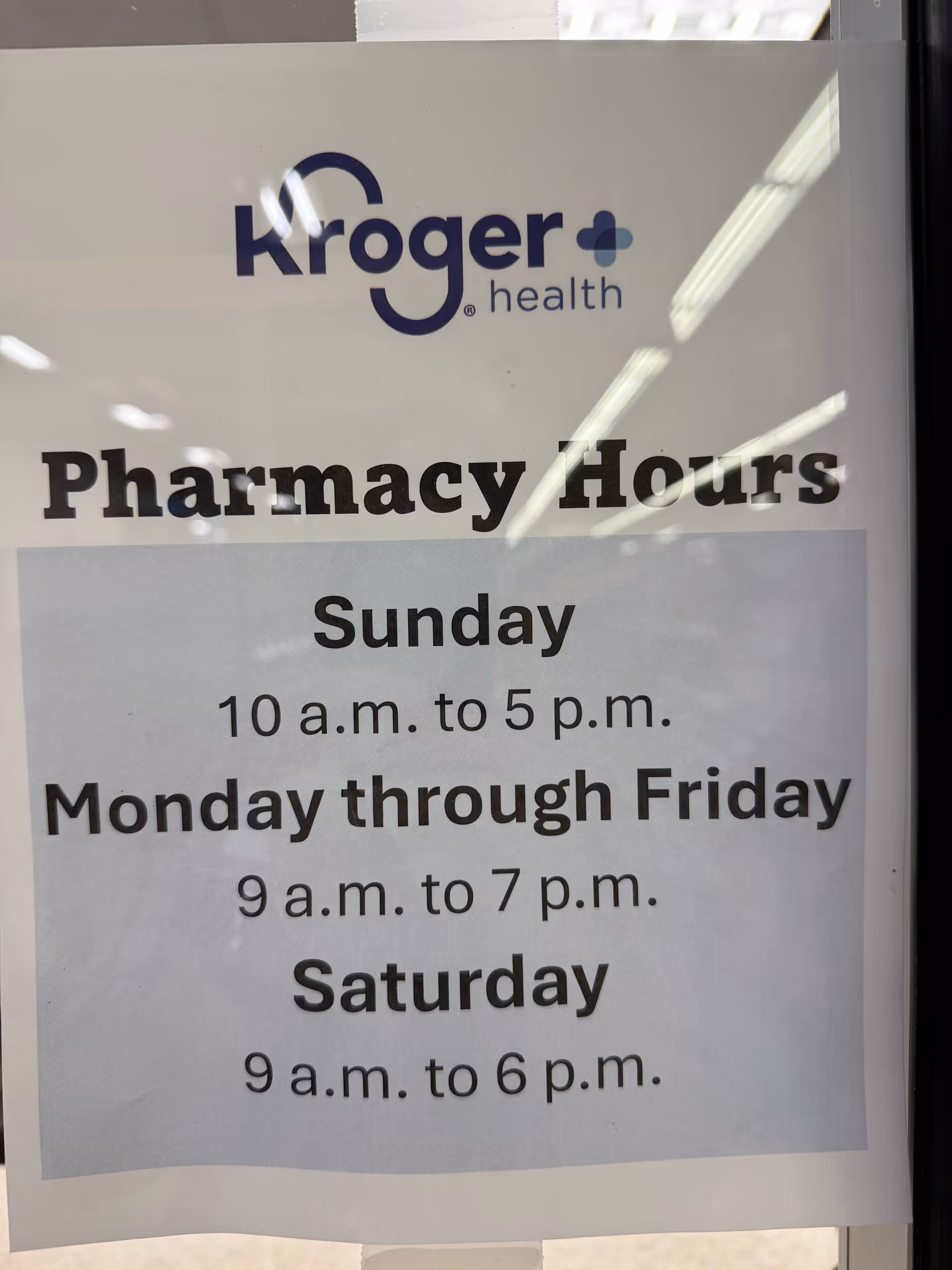 Storefront window sign displays Kroger Health Pharmacy Hours and weekly operating times.