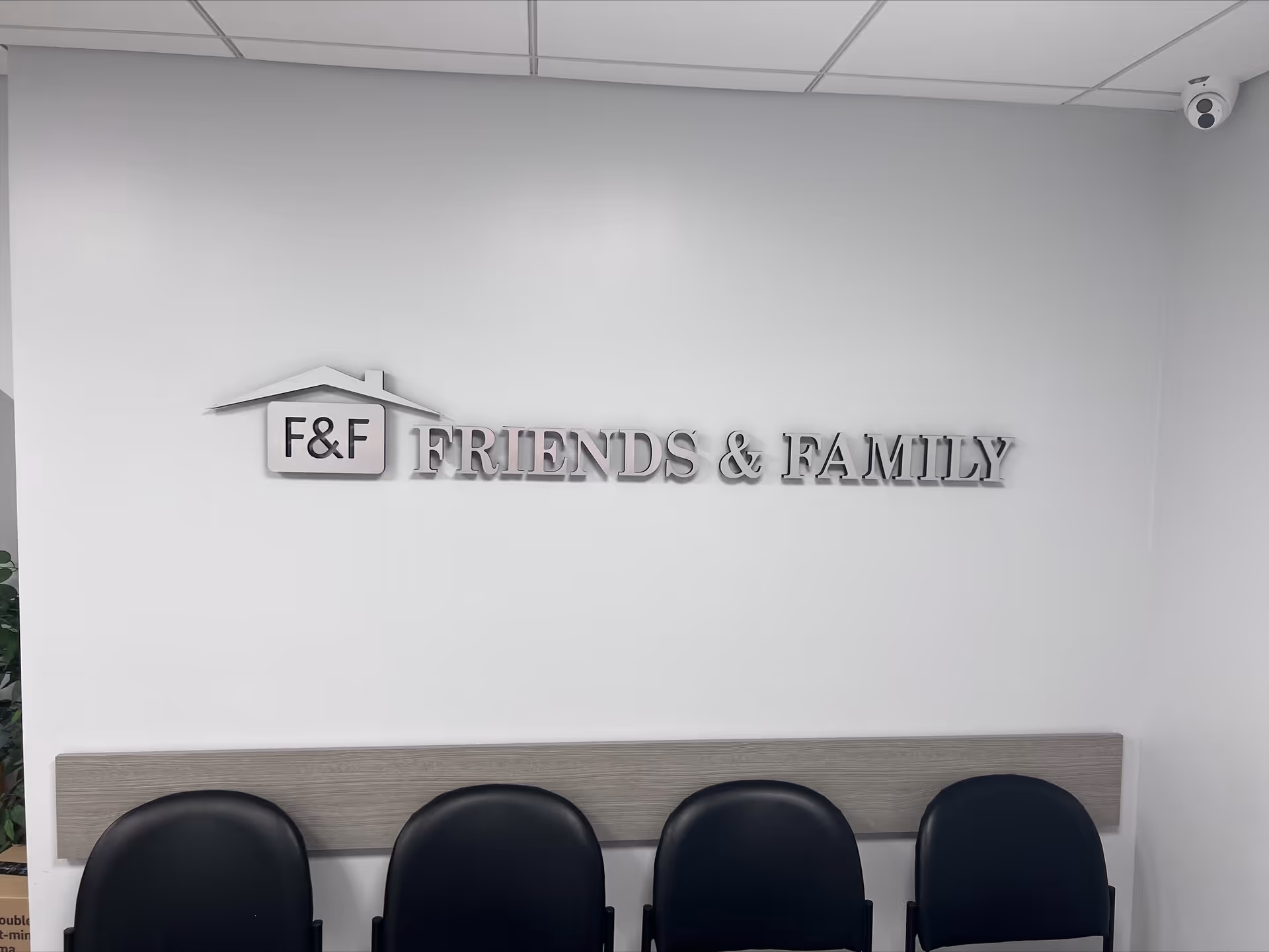 Interior lobby area with a sign 'Friends & Family' and row of black chairs.