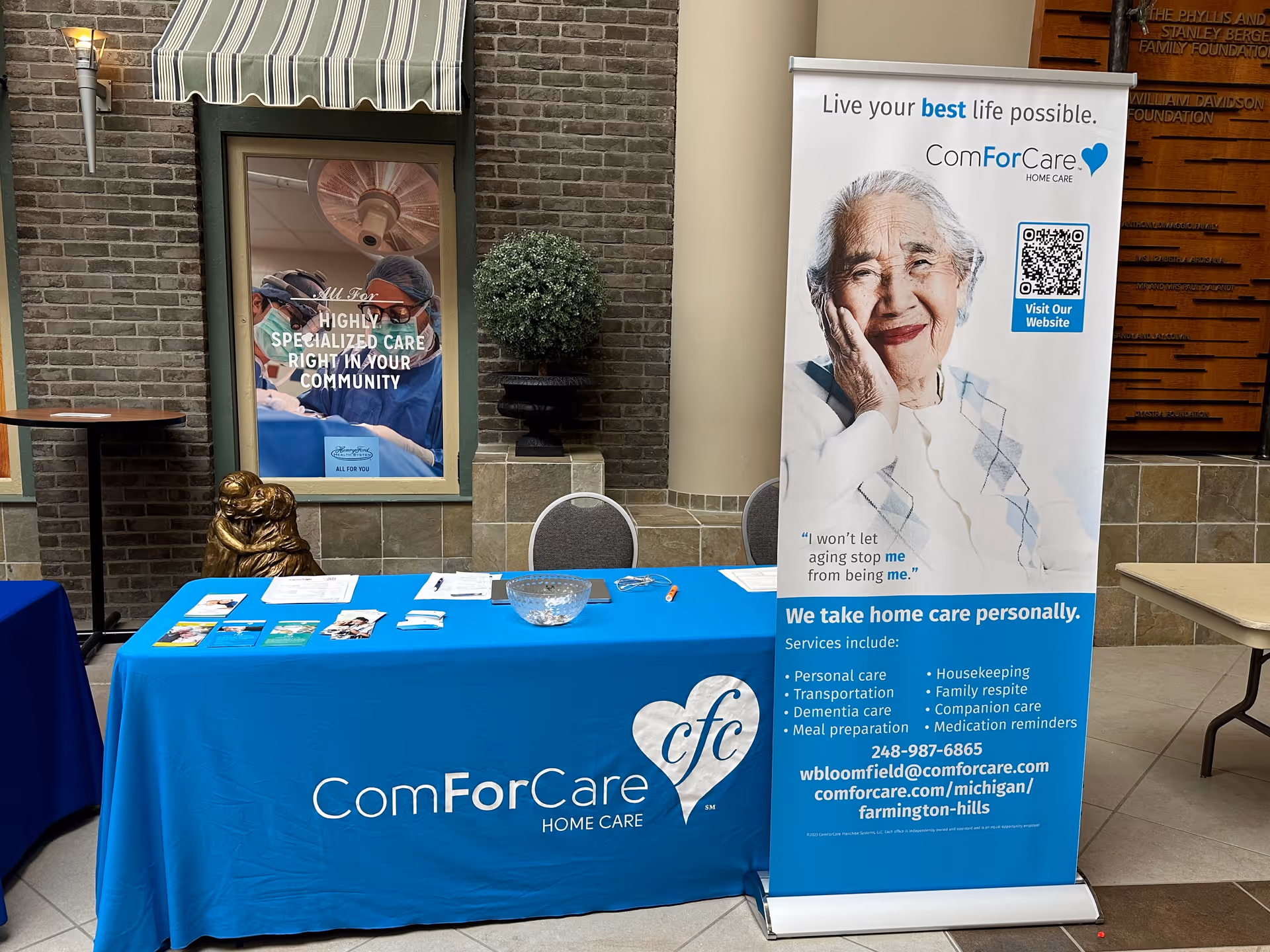 Promotional table with blue ComForCare banner inside a facility lobby.