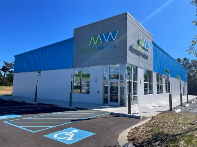Modern MobilityWorks facility with blue exterior, glass storefront, and accessible parking