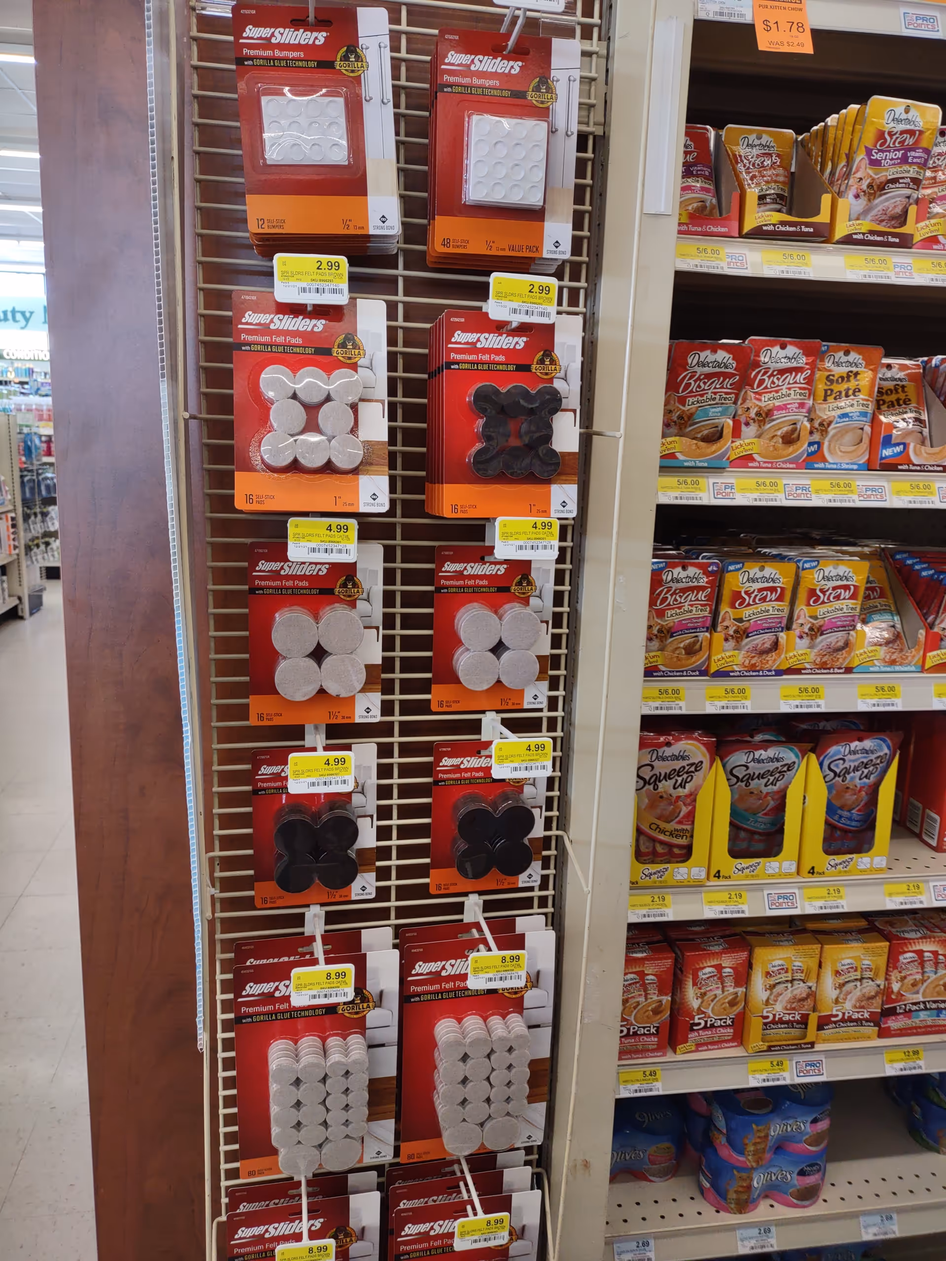 A store aisle with metal racks displaying pill organizers and packaged goods in a retail setting
