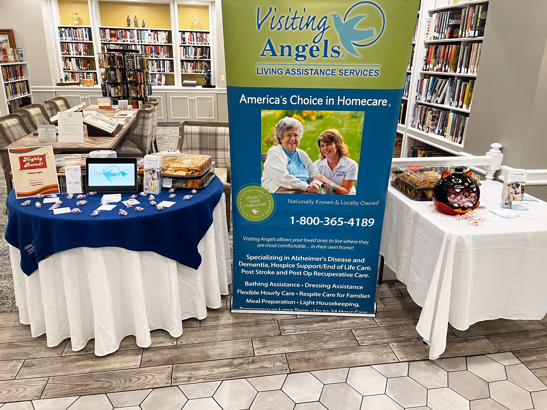 Indoor library area with a Visiting Angels banner and info tables.