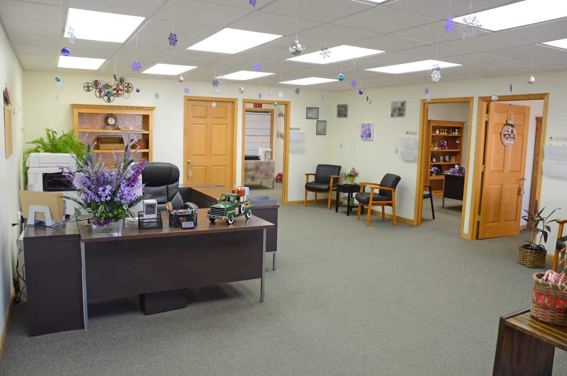 Reception area of Serenity Point Hospice, LLC, featuring a desk, seating, plants, and holiday decorations.
