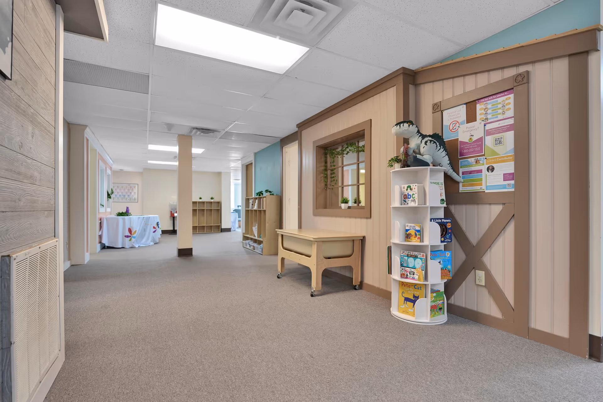 Wide interior hallway in a senior living facility with shelves and playful decor.