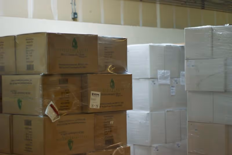 Stacks of cardboard boxes and wrapped pallets in a warehouse storage area.