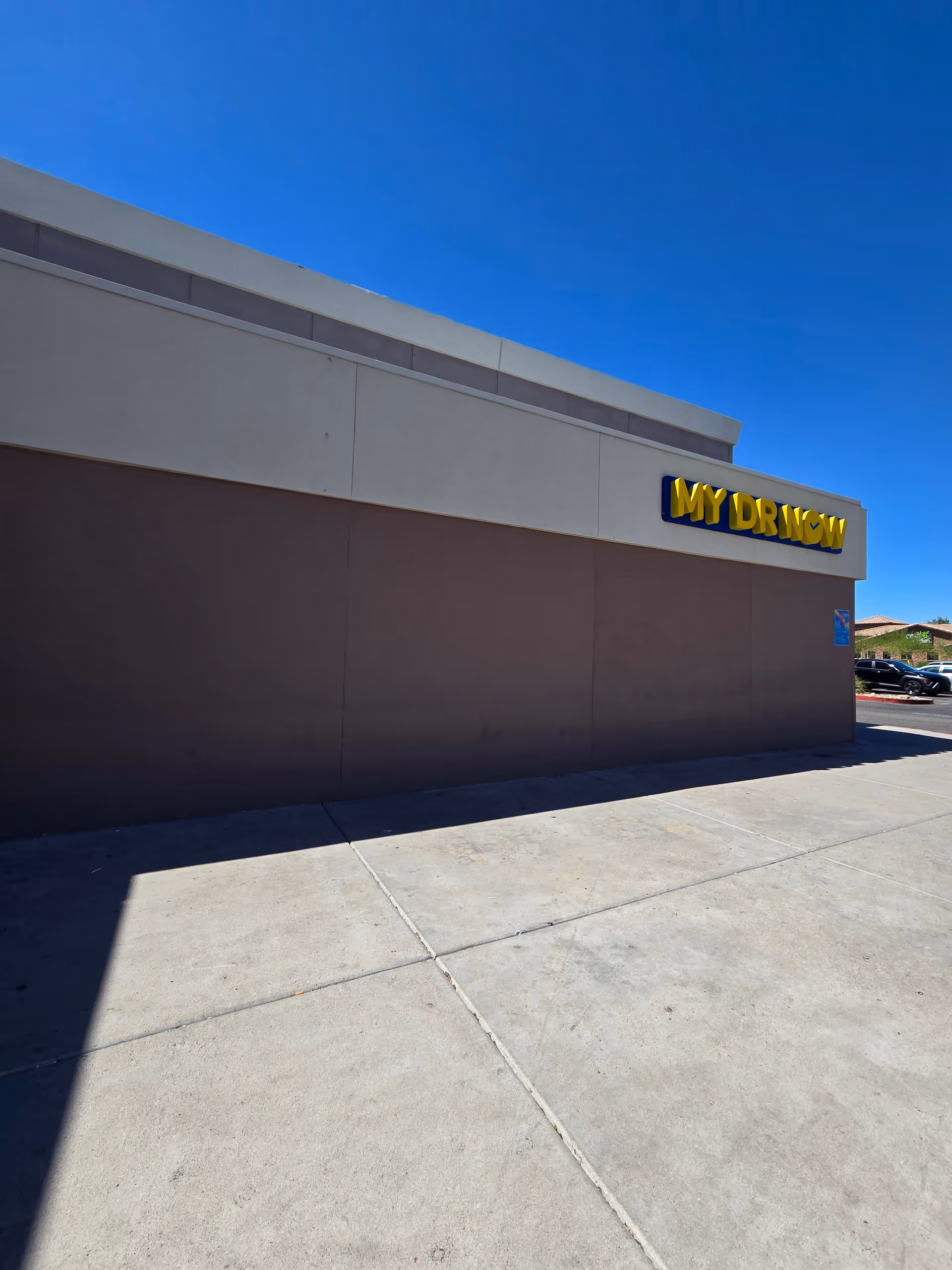 Exterior view of a facility with a MY DR NOW sign under a blue sky.