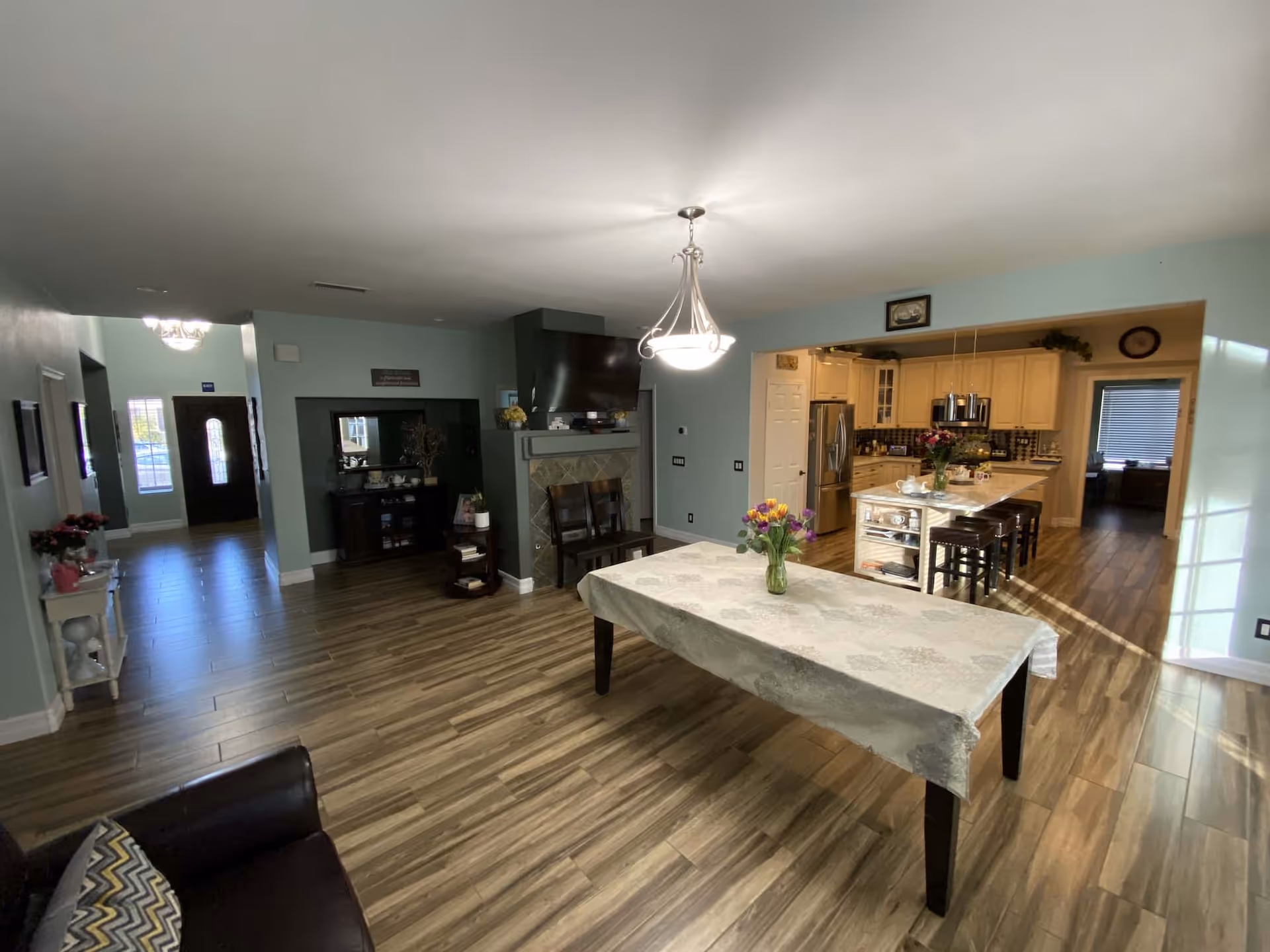 Open-concept living area with a dining table, fireplace, and adjacent modern kitchen.
