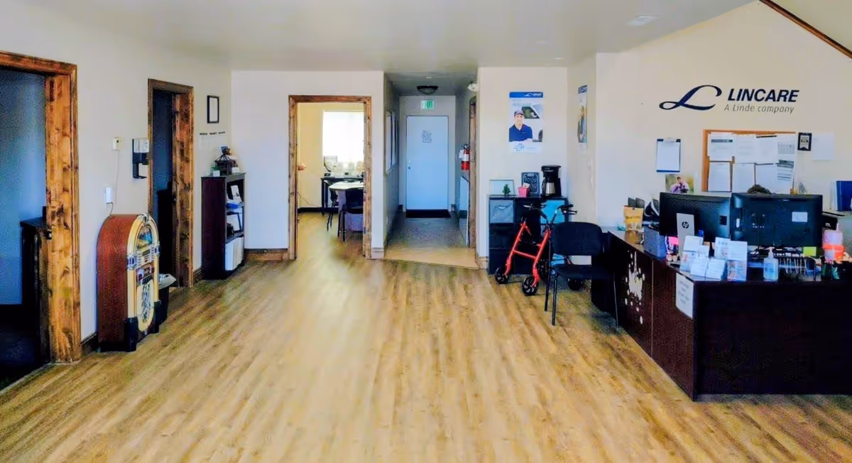 Reception area of LinCare facility with a front desk, hallway, and a walker.