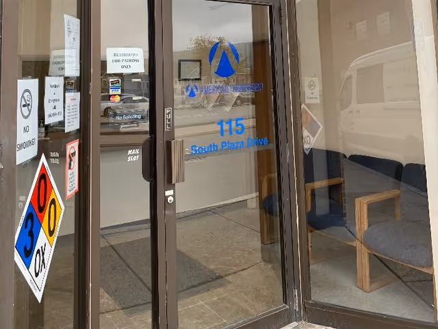 Glass entrance doors show blue signage with interior seating visible inside.
