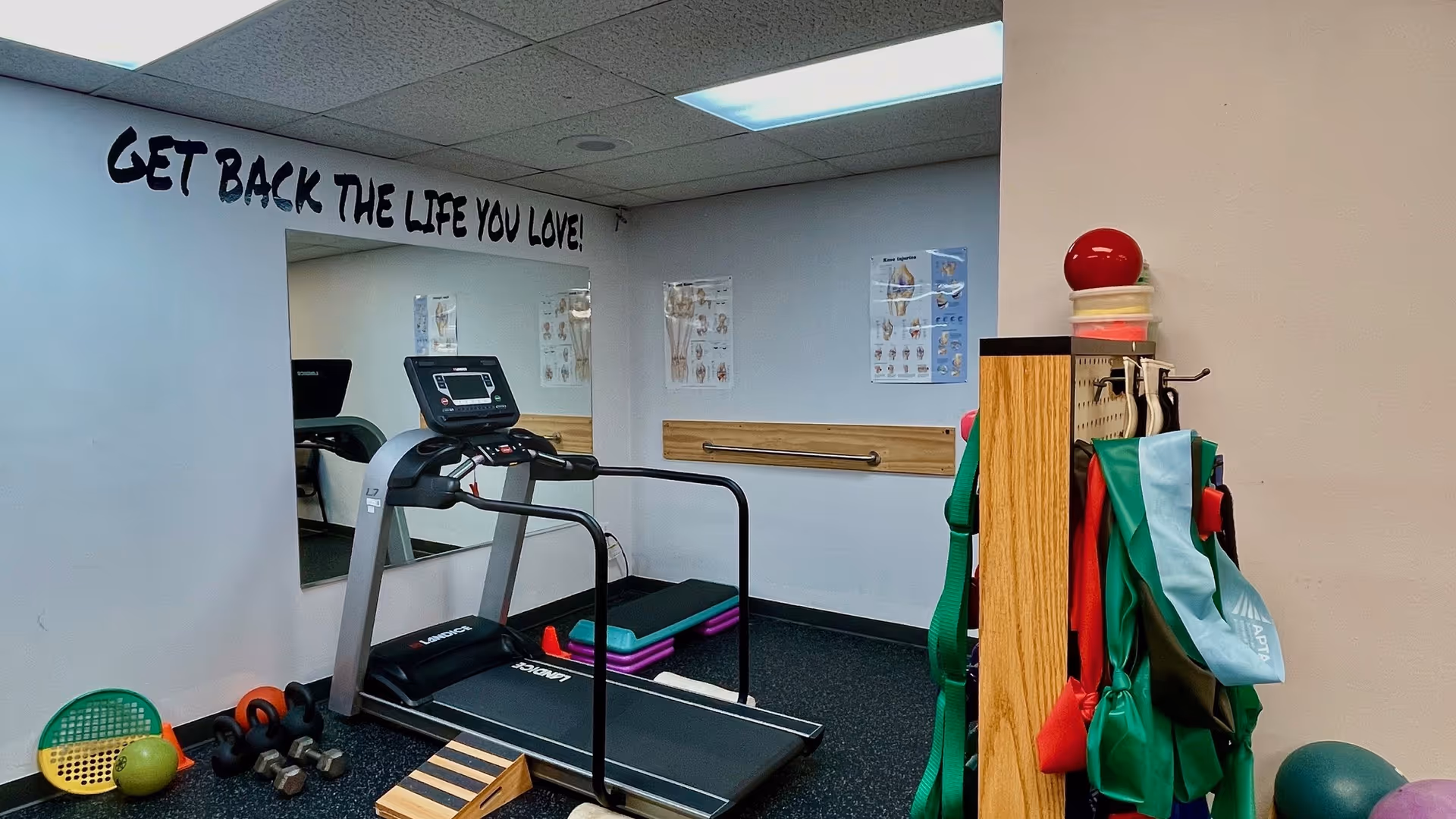 There is a treadmill and exercise equipment in a JAG Physical Therapy fitness room.