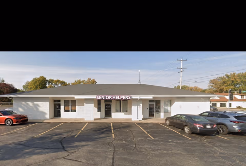 Single-story Senior Helpers facility with a white exterior and a front parking lot.
