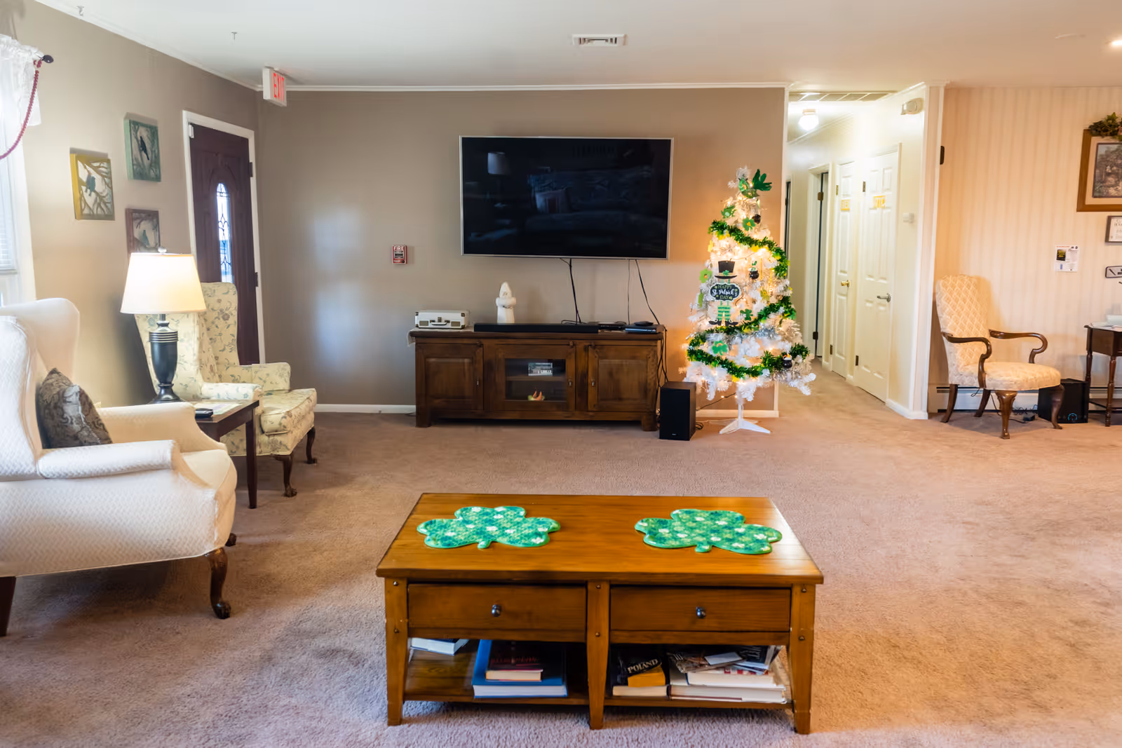 Cozy living room in a senior facility with a Christmas tree, TV, and seating.