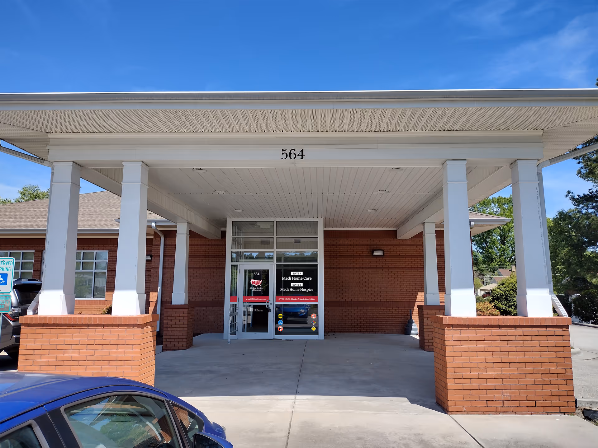 Entrance of Medi Home Care facility beneath a white canopy, brick columns, and the address 564.
