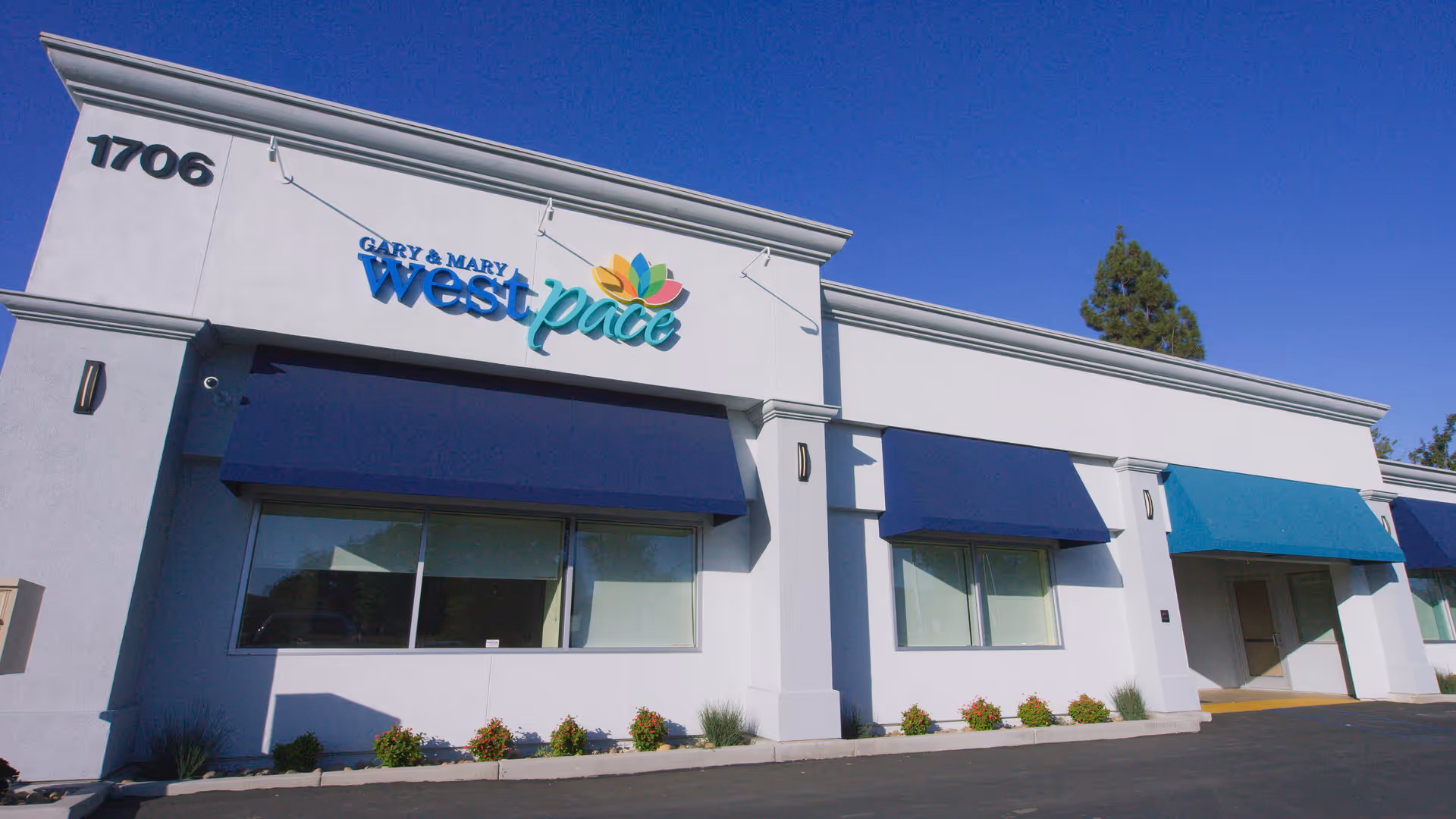 Front view of Gary and Mary West PACE building with blue awnings
