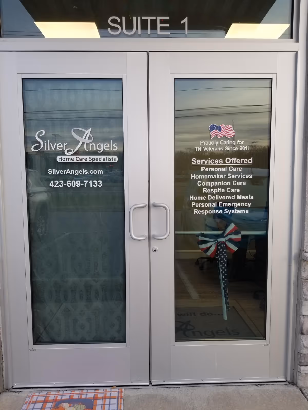 Glass double doors branded with Silver Angels; Suite 1 above, services listed on the right.