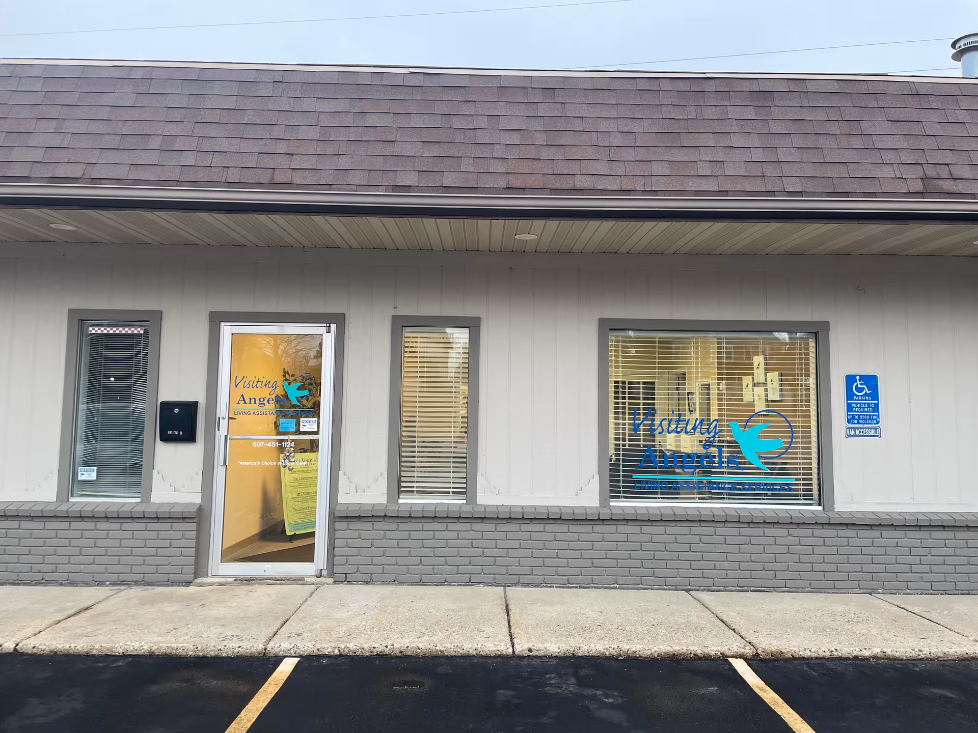 Exterior view of Visiting Angels Senior Home Care storefront with door, window, and accessible sign.