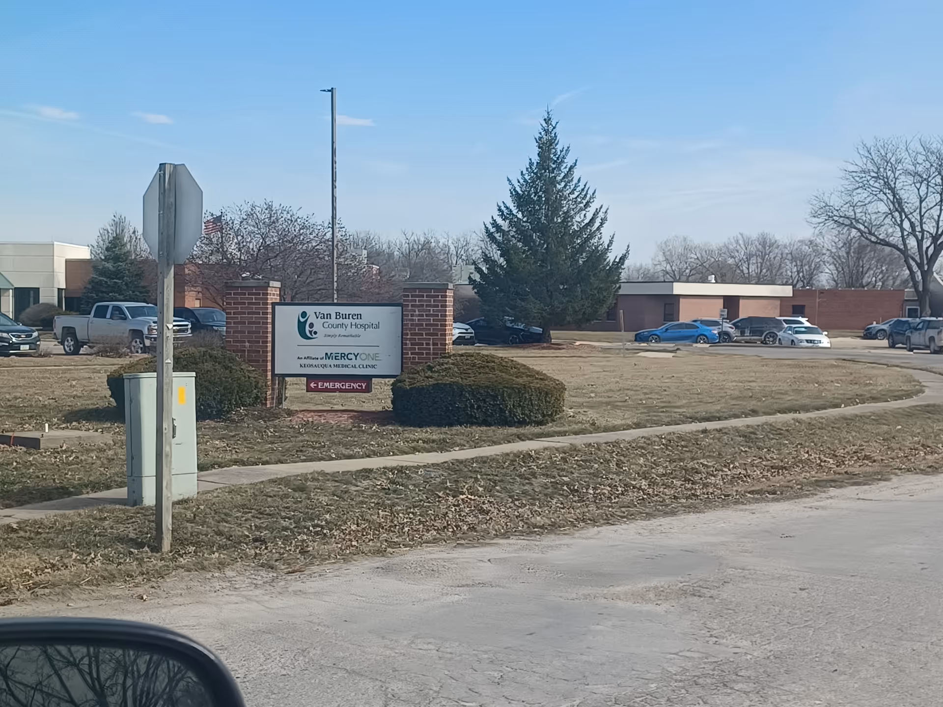 Exterior view of Van Buren County Hospital campus with a sign and parked cars.