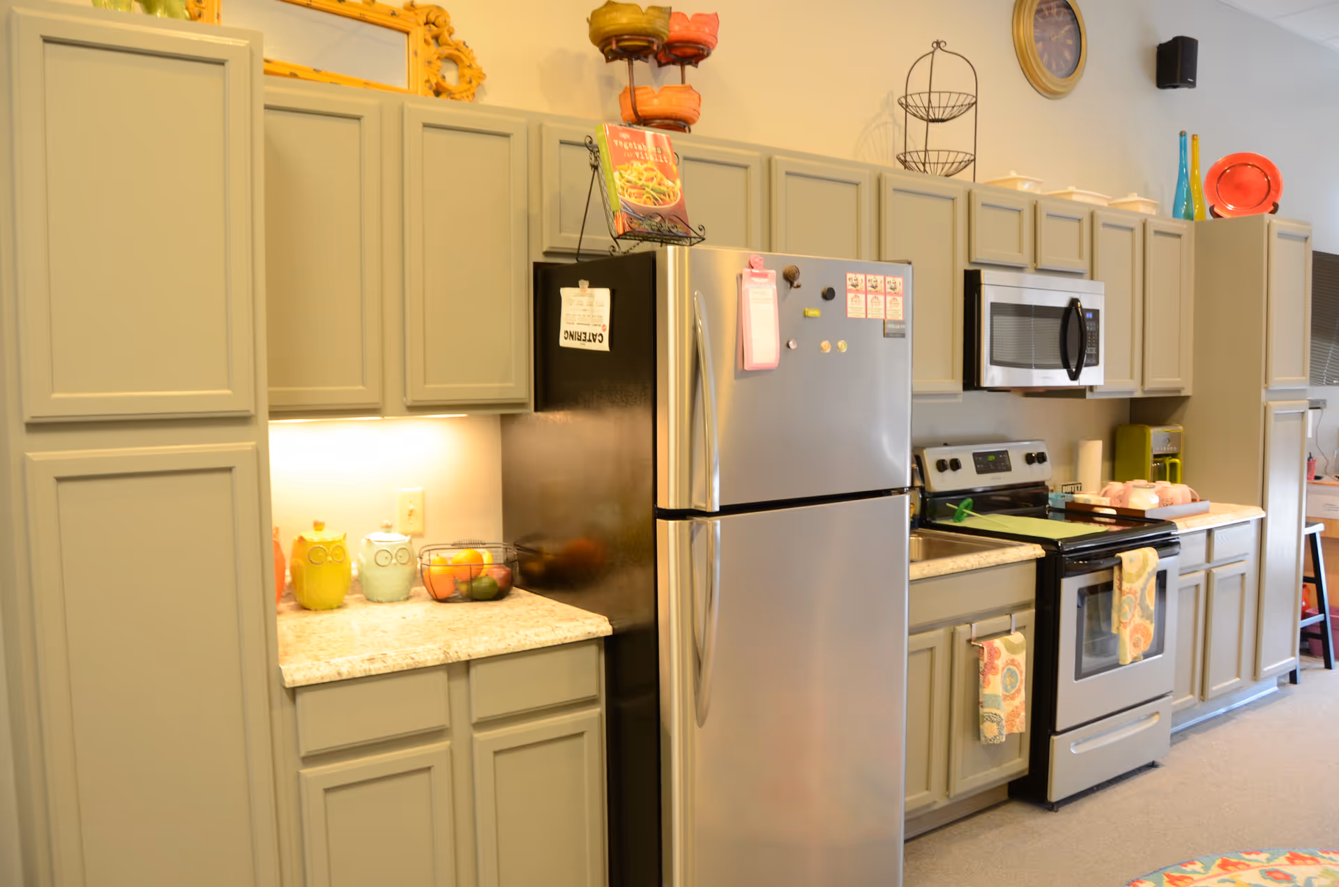 A gray kitchen with stainless appliances, abundant cabinetry, and a speckled countertop.