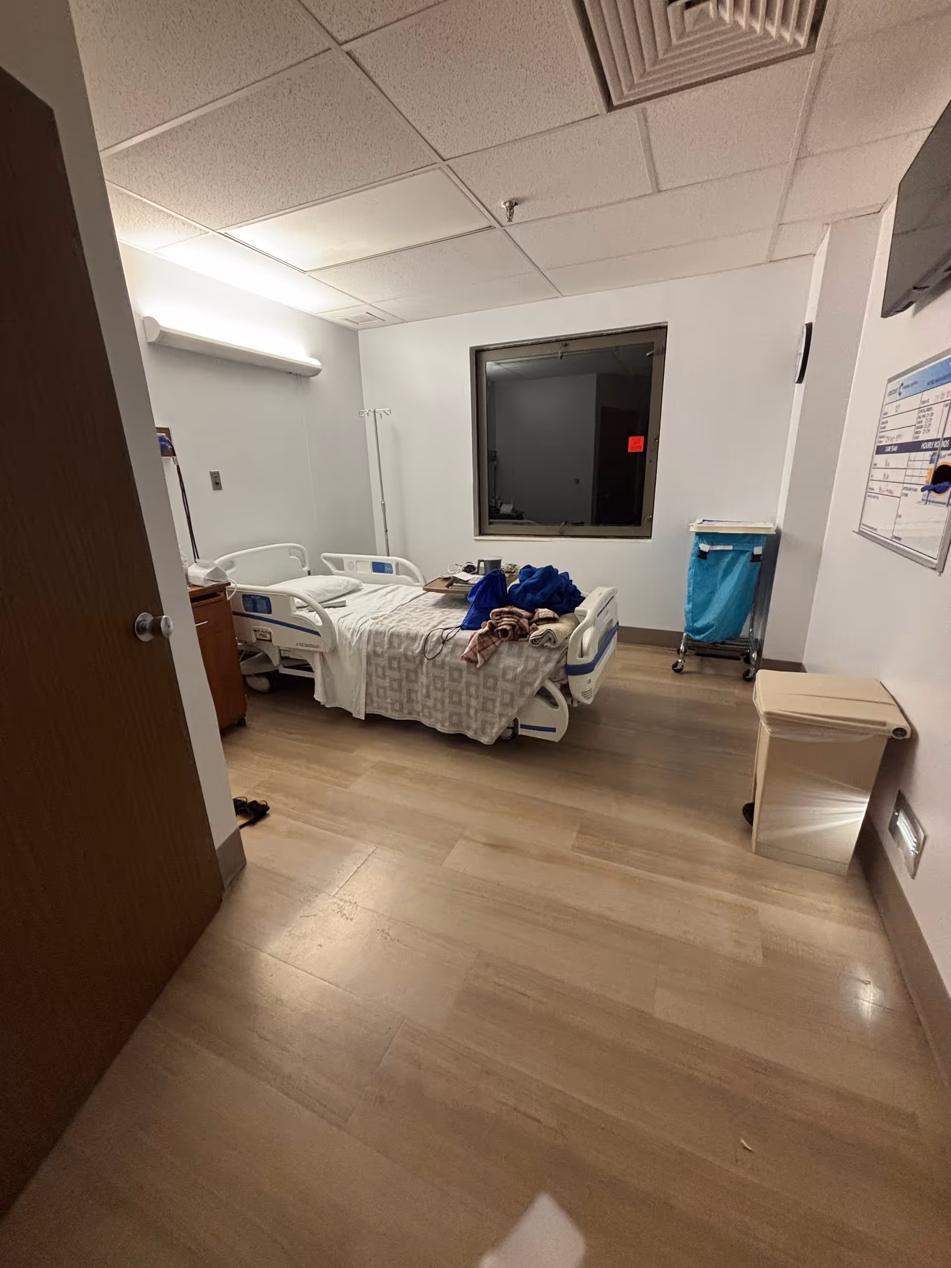 A hospital room with a bed, medical equipment, and a window.