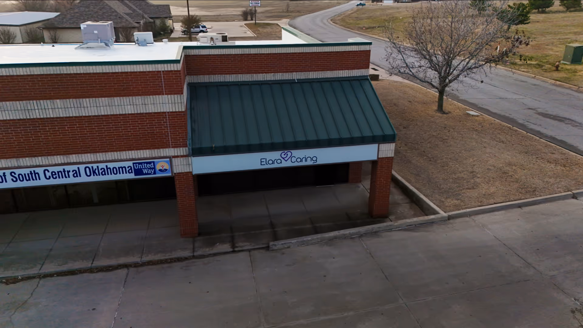 Exterior storefront of Elara Caring with green awning and sidewalk.