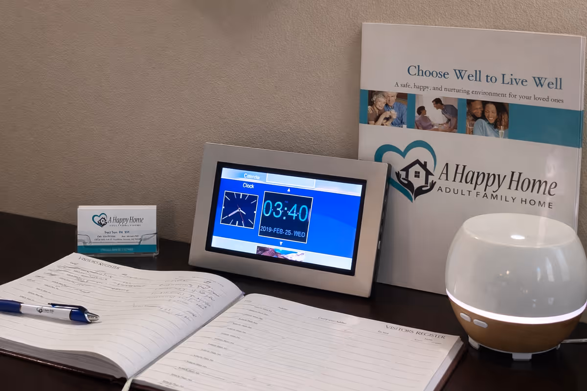 Interior desk setup at A Happy Home facility with tablet, brochure, notebook, and diffuser.