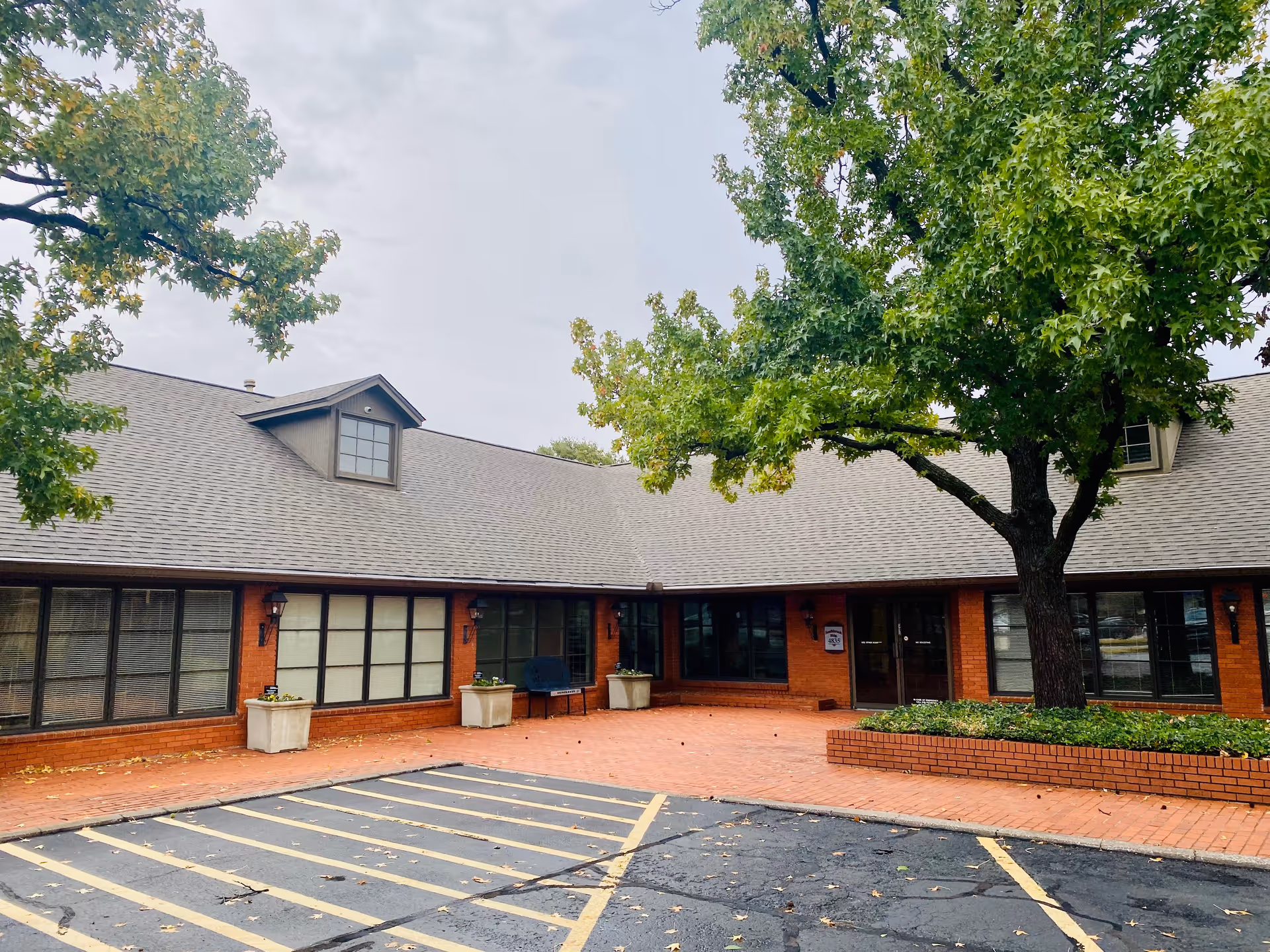 Exterior view of a Cornerstone Caregiving facility with brick walls, windows, and a brick courtyard.