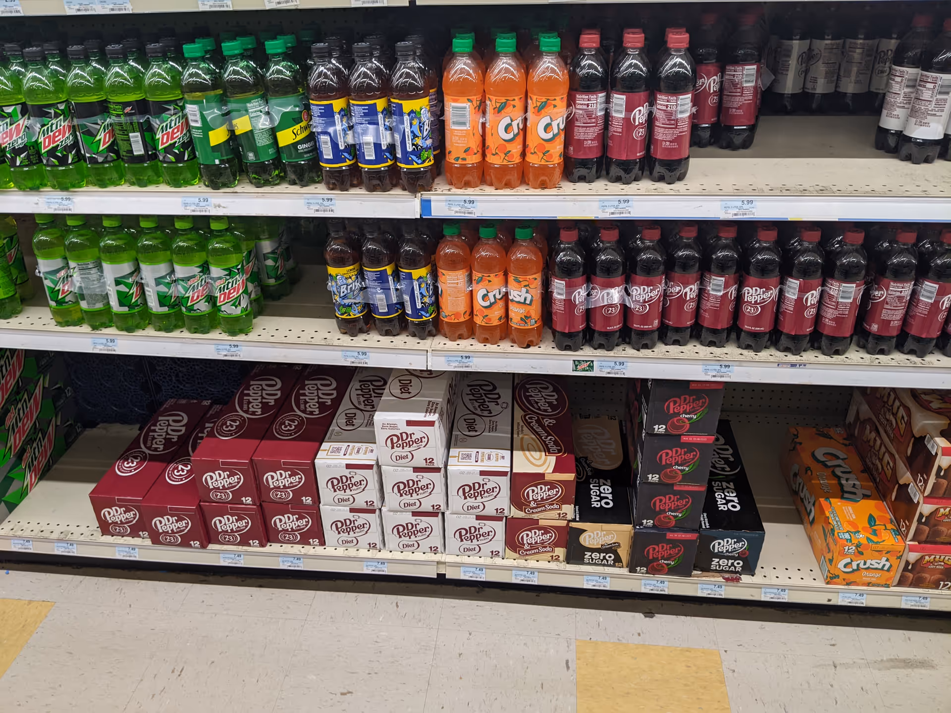 Inside Discount Drug Mart, shelves display assorted soda bottles and cases.