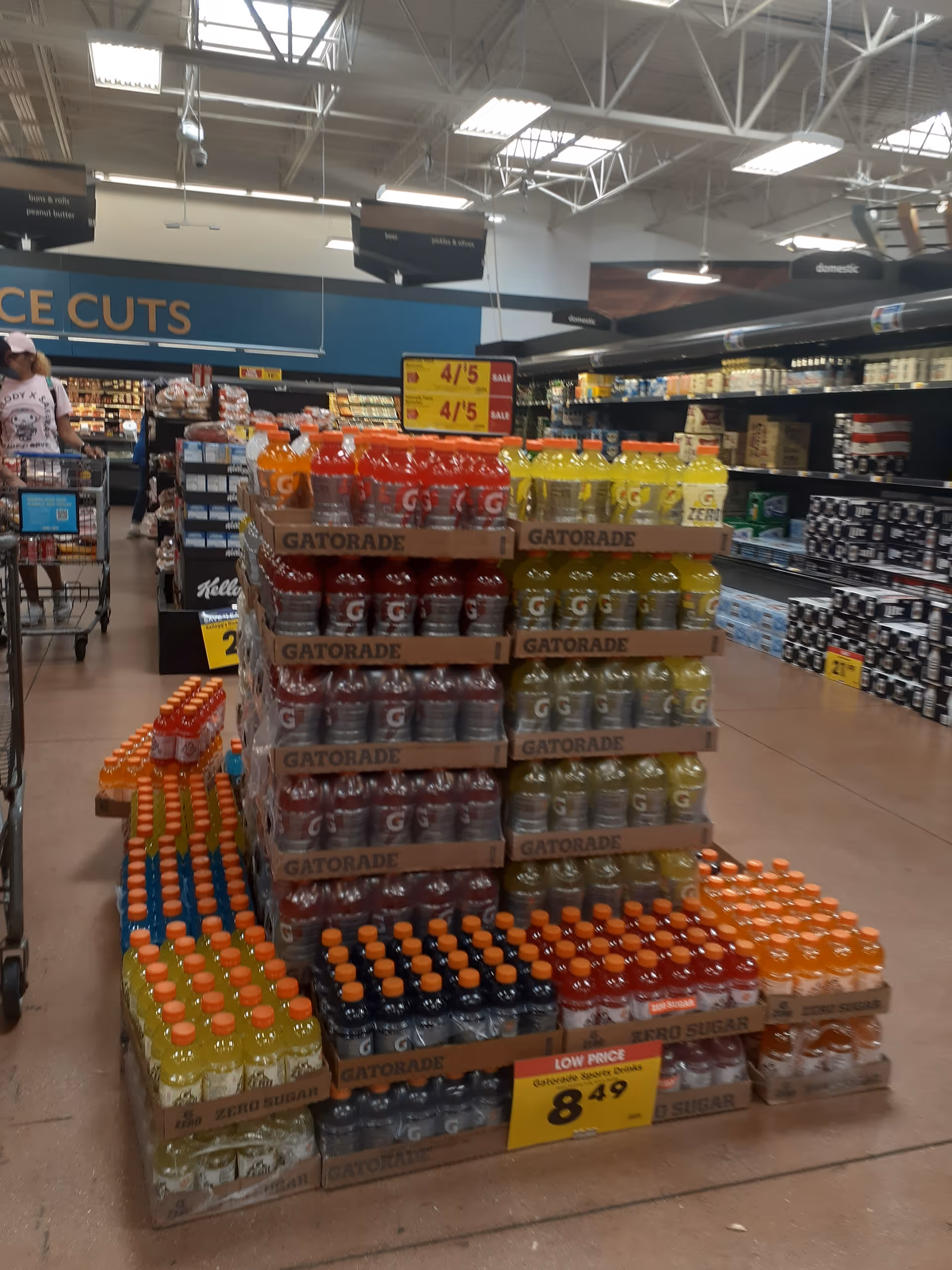 Pallets of Gatorade and other beverages stacked in a grocery store aisle.