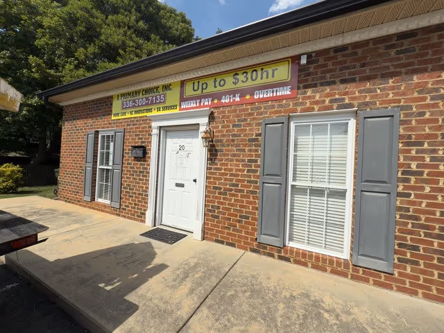 Brick building with signs advertising home care services and rates.