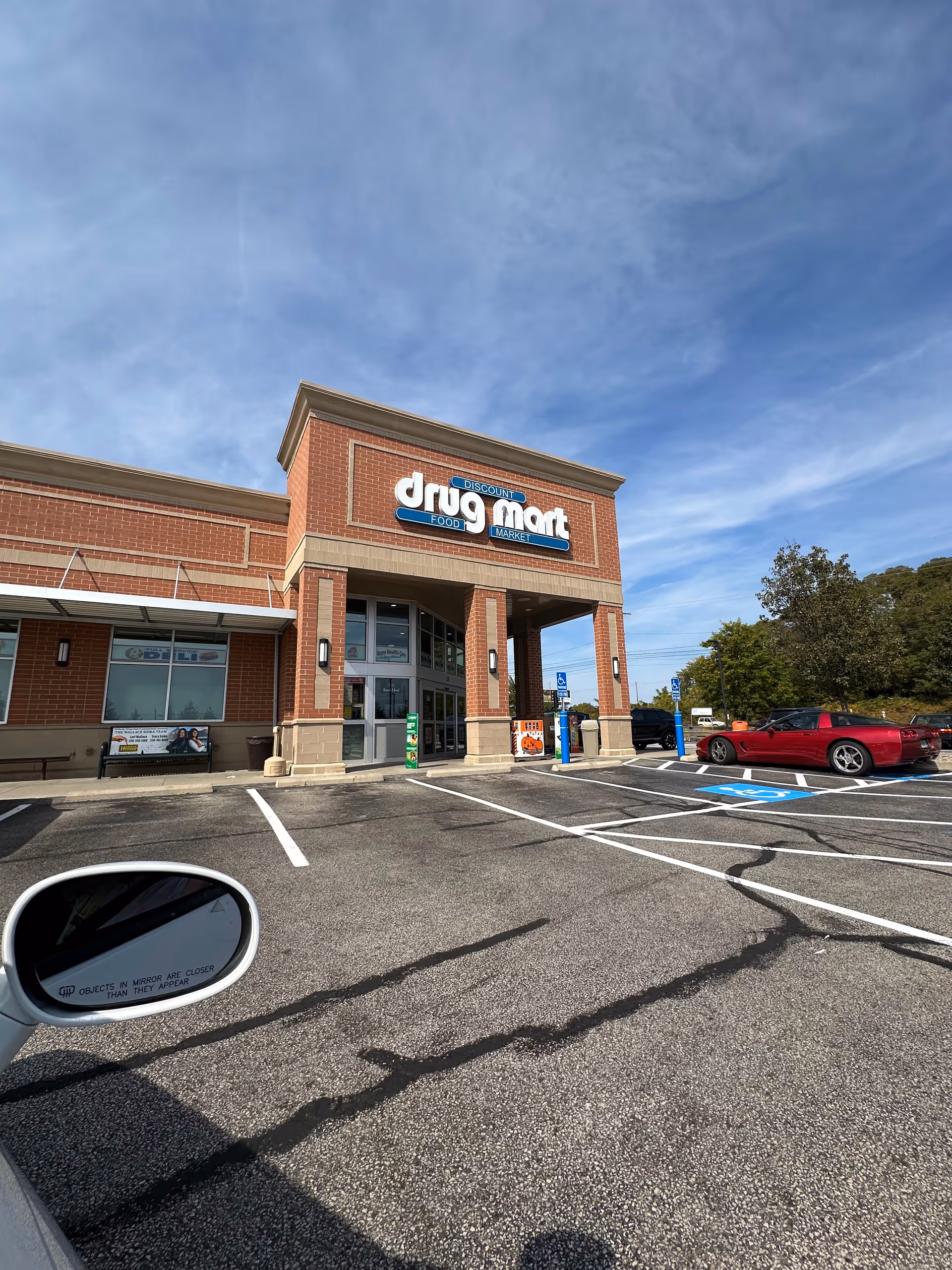 Exterior view of a Discount Drug Mart storefront with brick facade and parking lot.