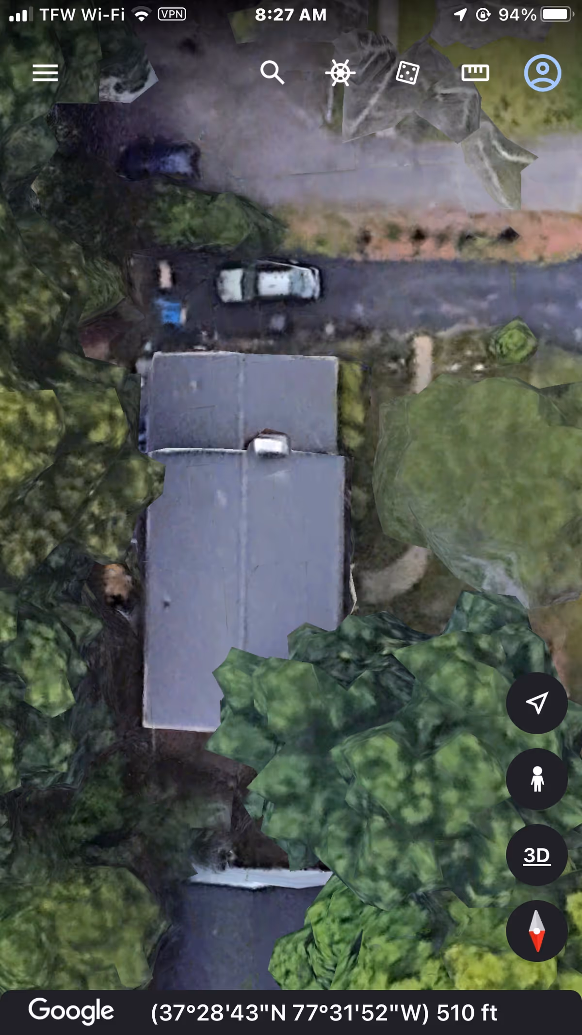 Aerial view of a single-story building surrounded by dense trees.