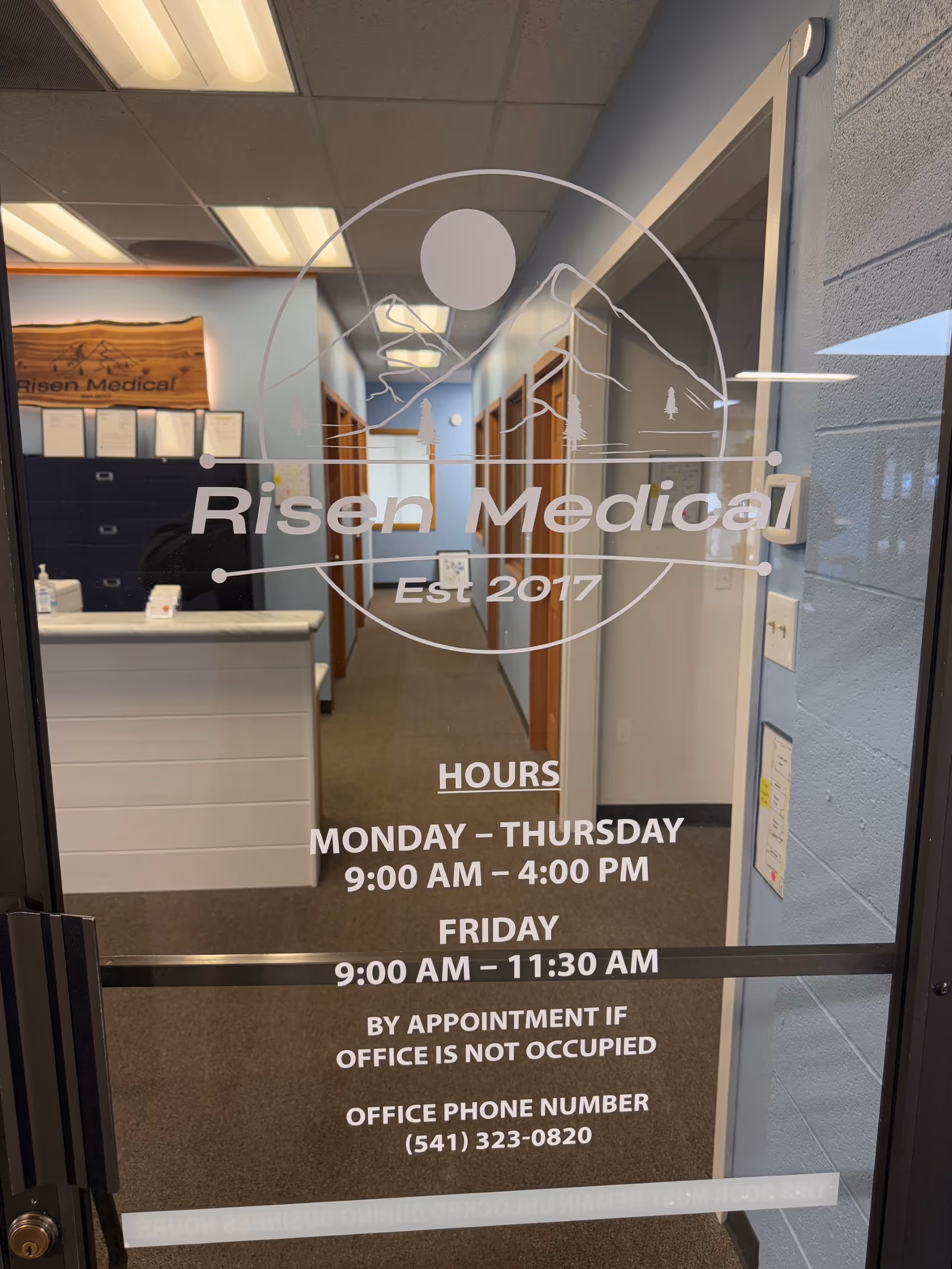 Glass front door with Risen Medical logo, hallway and reception desk visible inside.
