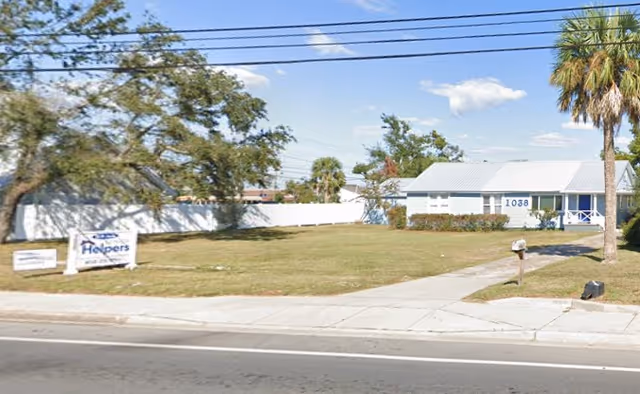 Exterior view of Senior Helpers facility with lawn, driveway and sidewalk.