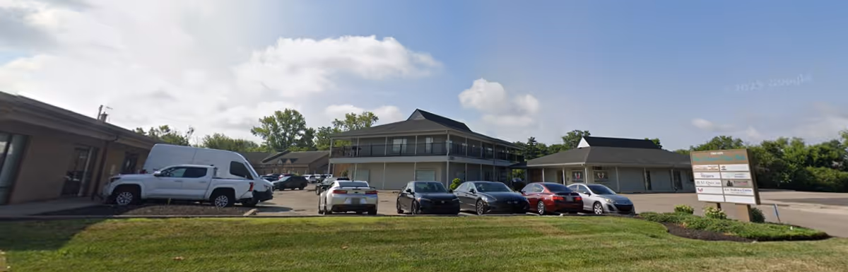 Exterior view of Senior Helpers facility with parking lot and sign.