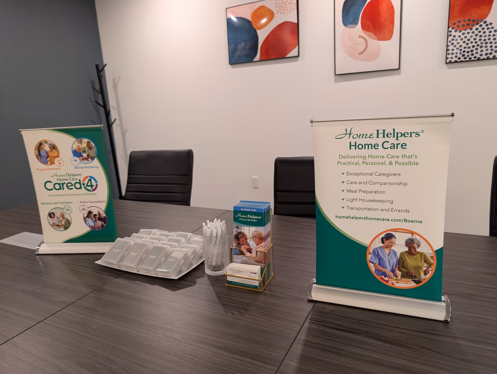 Reception area with two banners, brochures, and a dark wood conference table.