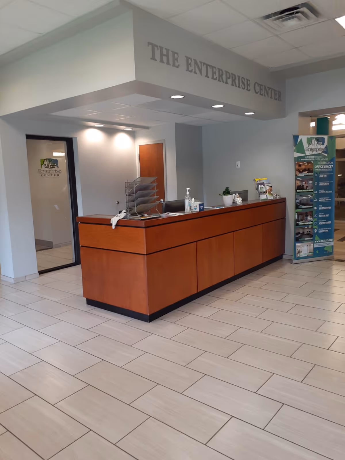 Interior lobby with wood reception desk and signage reading The Enterprise Center, prominently displayed.