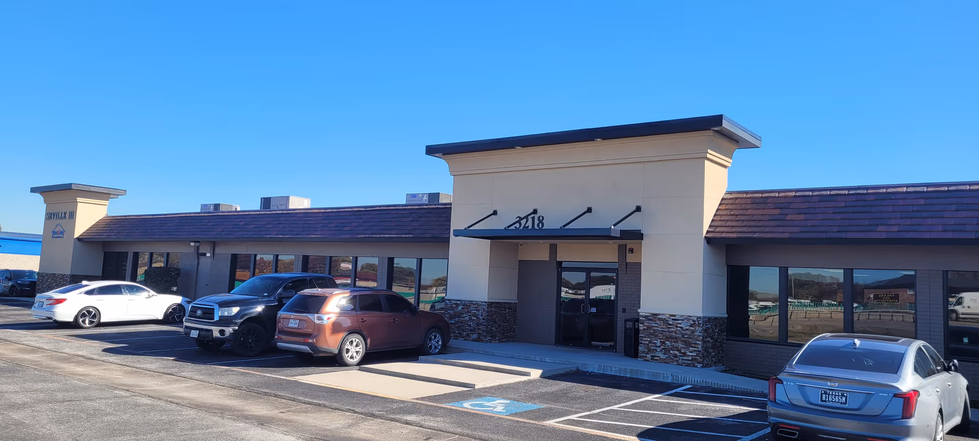 Front exterior of Cornerstone Caregiving facility with several cars parked out front.