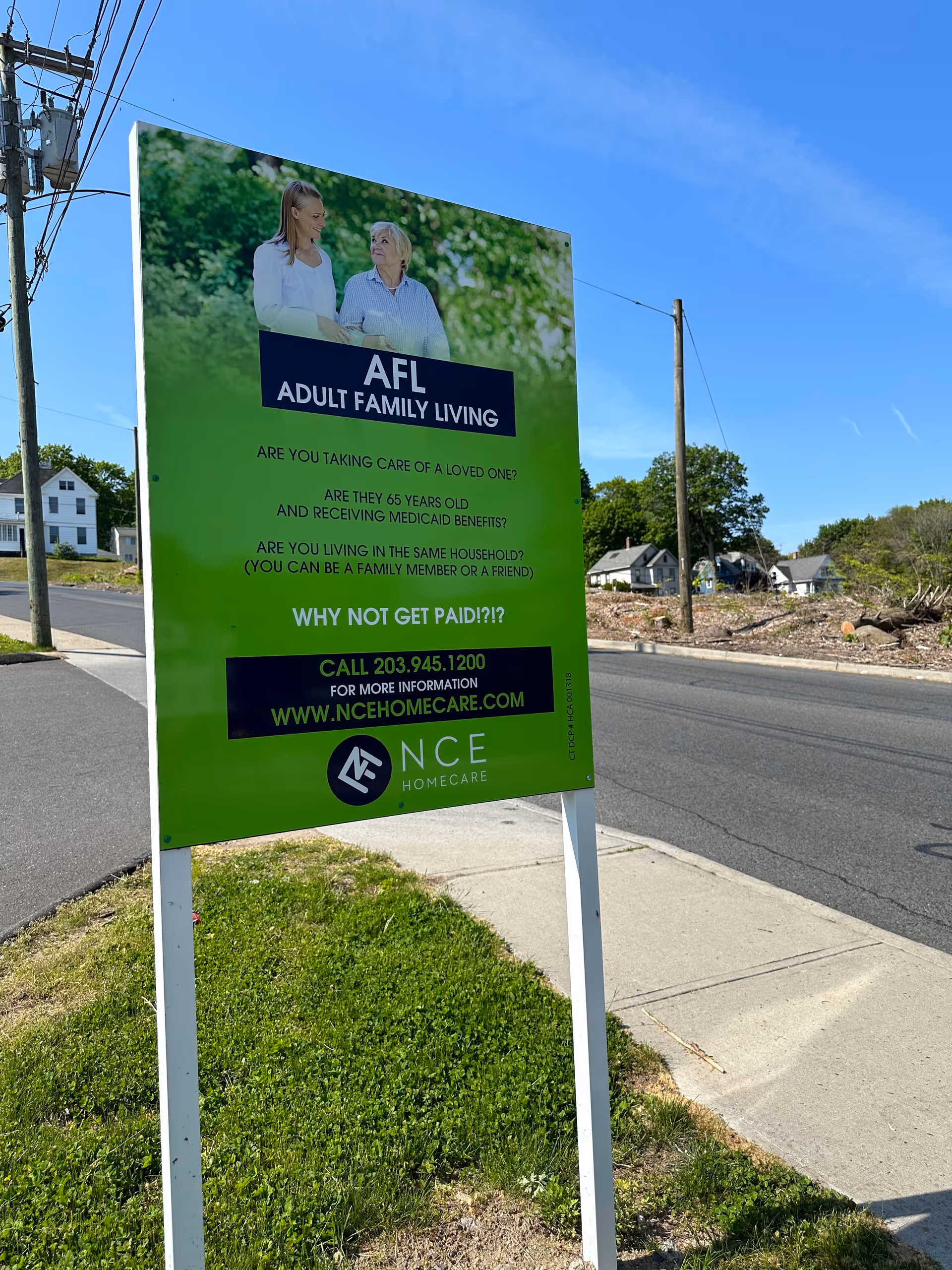 Outdoor advertising sign for NCE Homecare's Adult Family Living along a roadside.