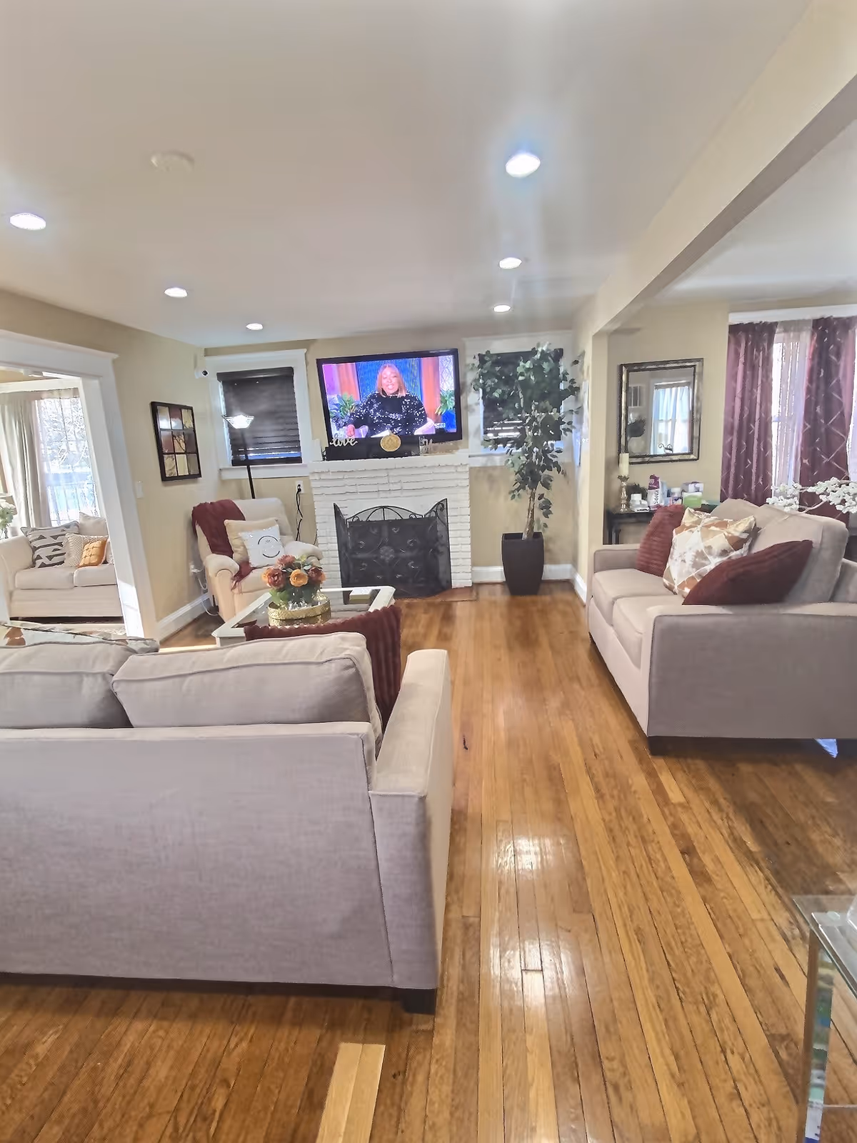 Bright senior living lounge with sofas, coffee table, and fireplace.