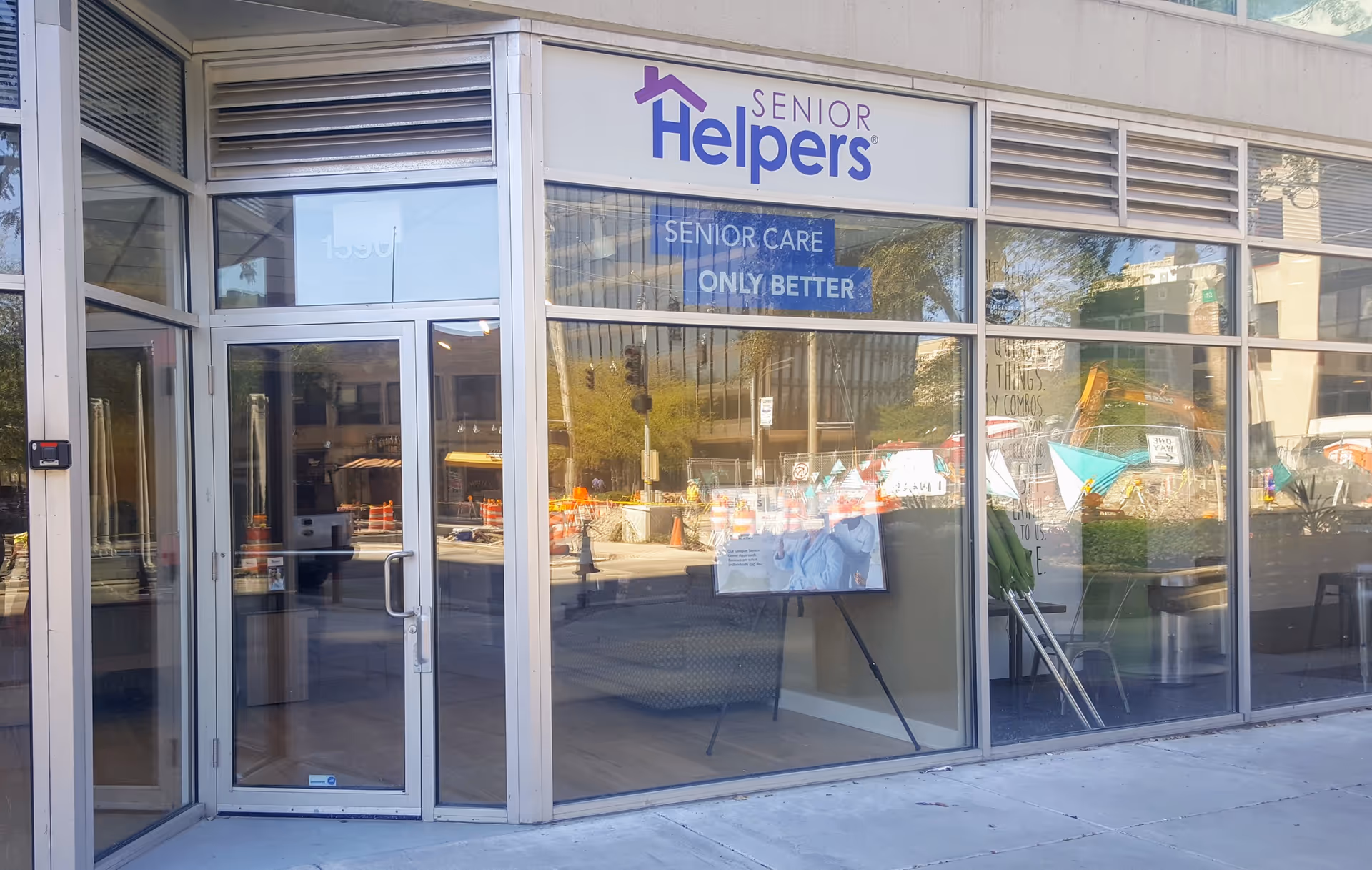 Glass storefront of Senior Helpers with entrance door and Senior Care signage.