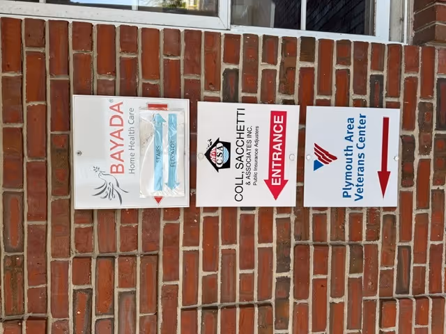 Brick exterior wall with three BAYADA Home Health Care and entrance signs.