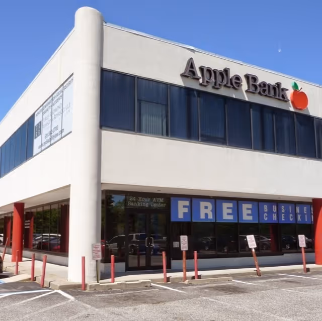 Two-story bank building with Apple Bank signage and large blue FREE signs.